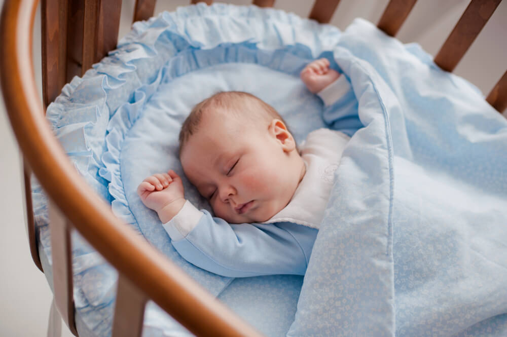 青いオーガニックのベビー布団で寝る赤ちゃん