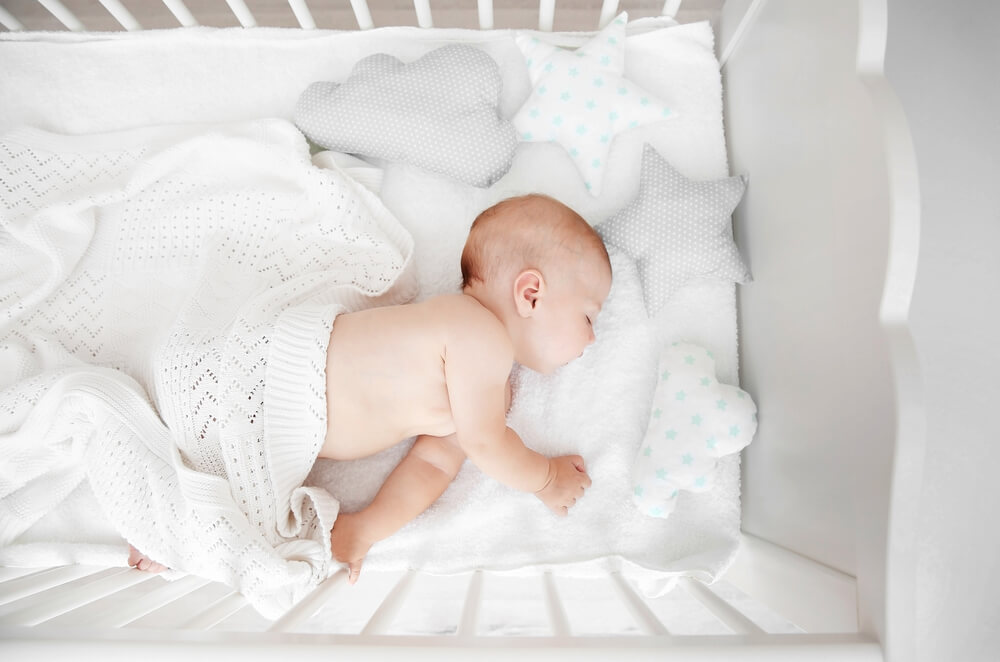 白いベビーベッドとオーガニック ベビー布団で寝る赤ちゃん